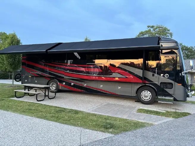 Class A diesel pusher on a paved pull-through site at Two Rivers Campground